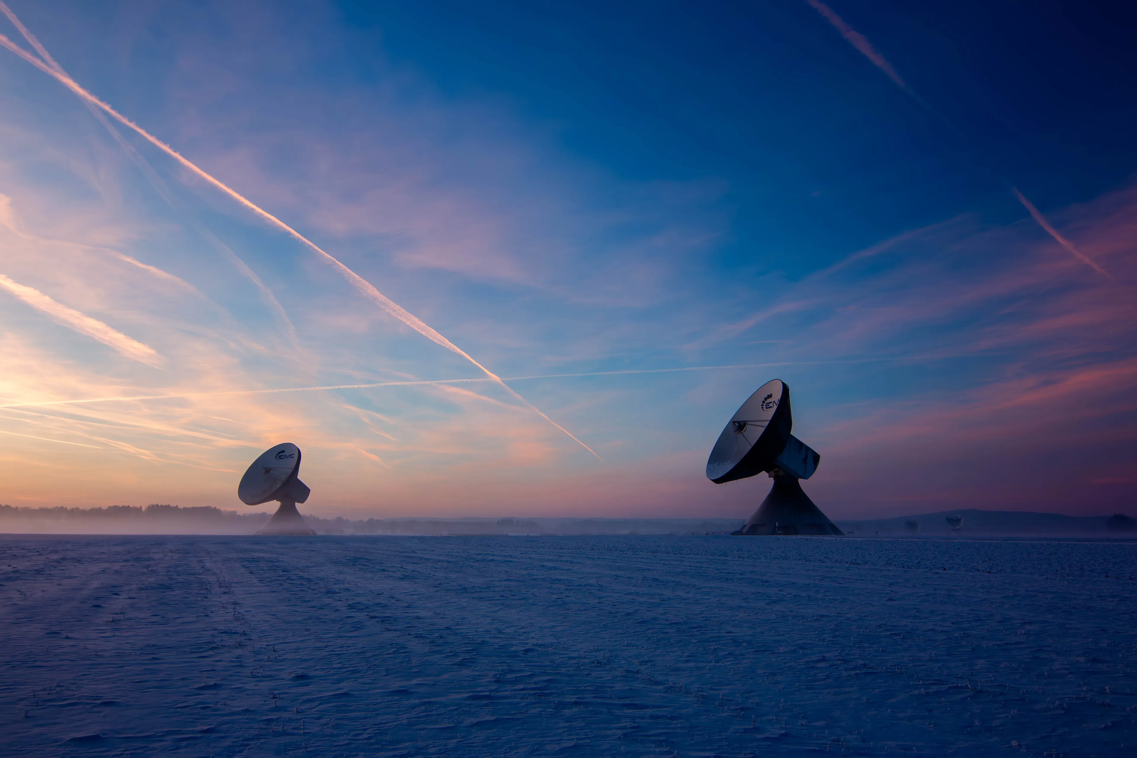 Zwei Parabolantennen der Erdfunkstelle Raisting in der verschneiten Ebene