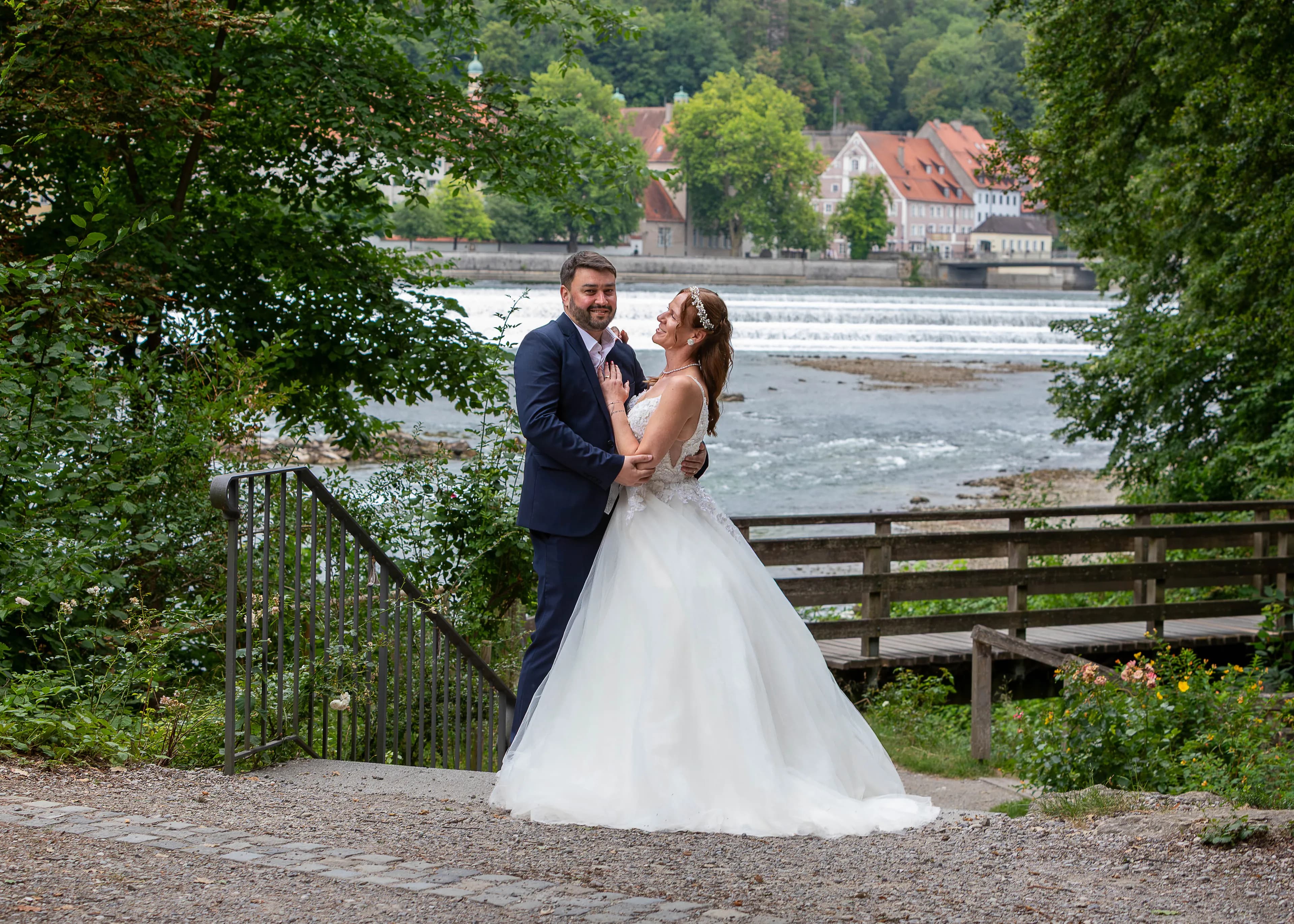 Brautpaar am Lechufer in Landsberg, im Rücken das rauschende Lechwehr und die Altstadt
