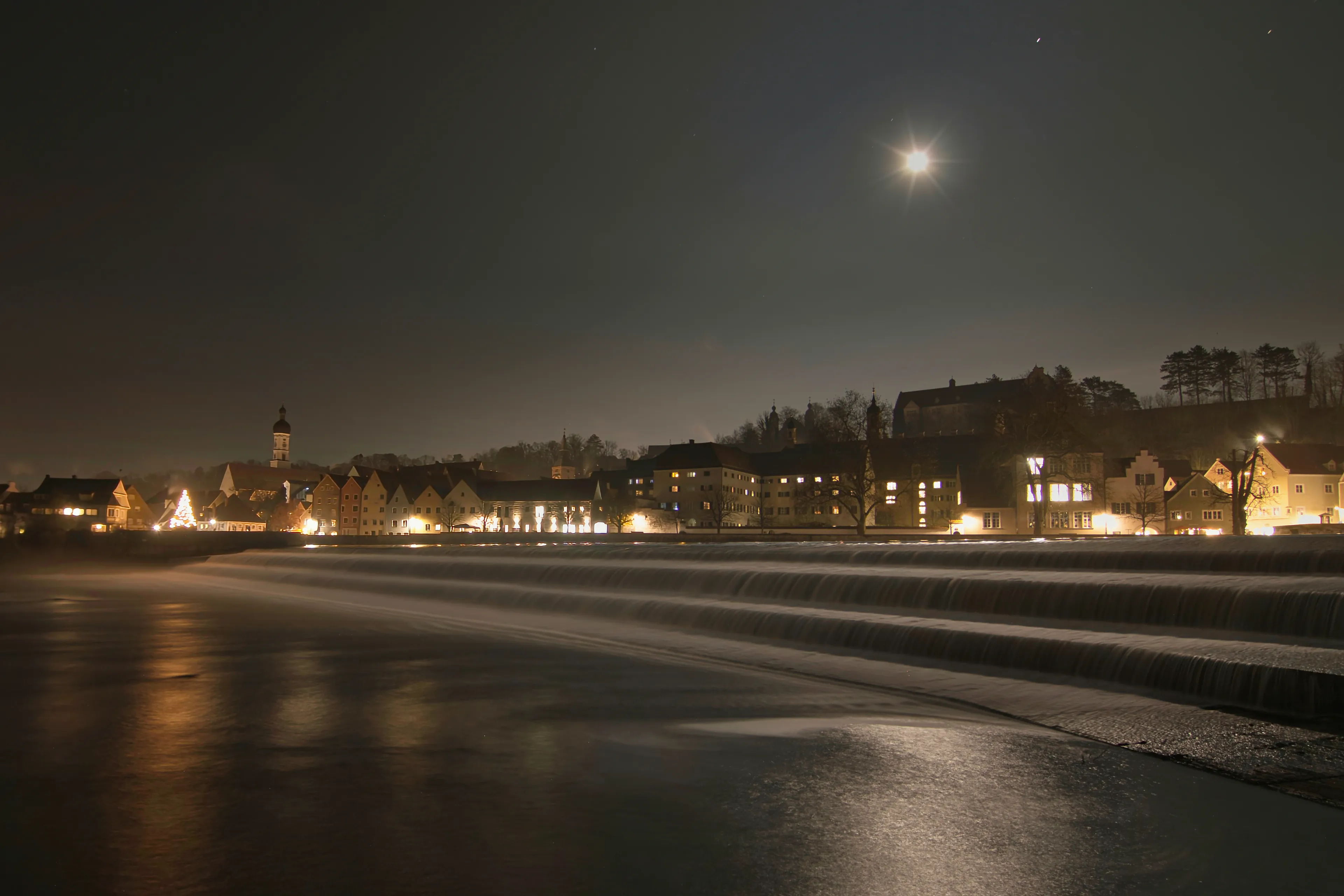 Landsberg am Lech bei Nacht: Mondlicht über dem Wehr und der beleuchteten Altstadt
