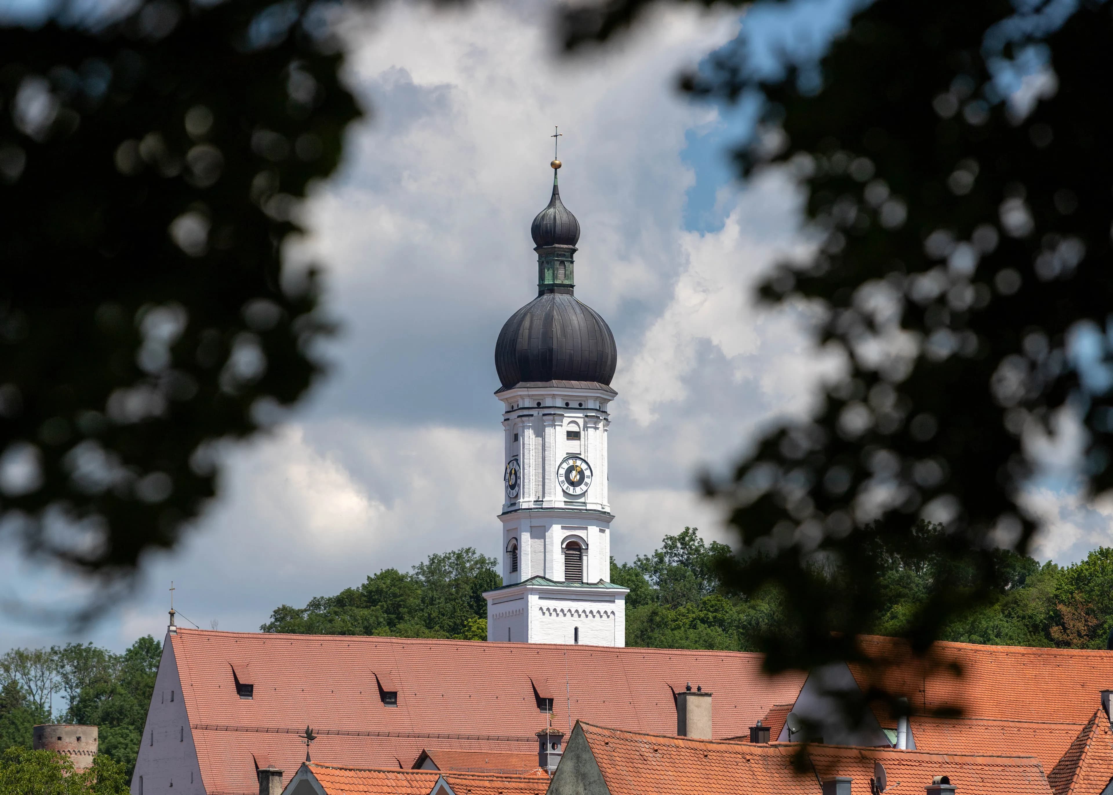 Der Zwiebelturm der Landsberger Stadtpfarrkirche über den Dächern der Altstadt